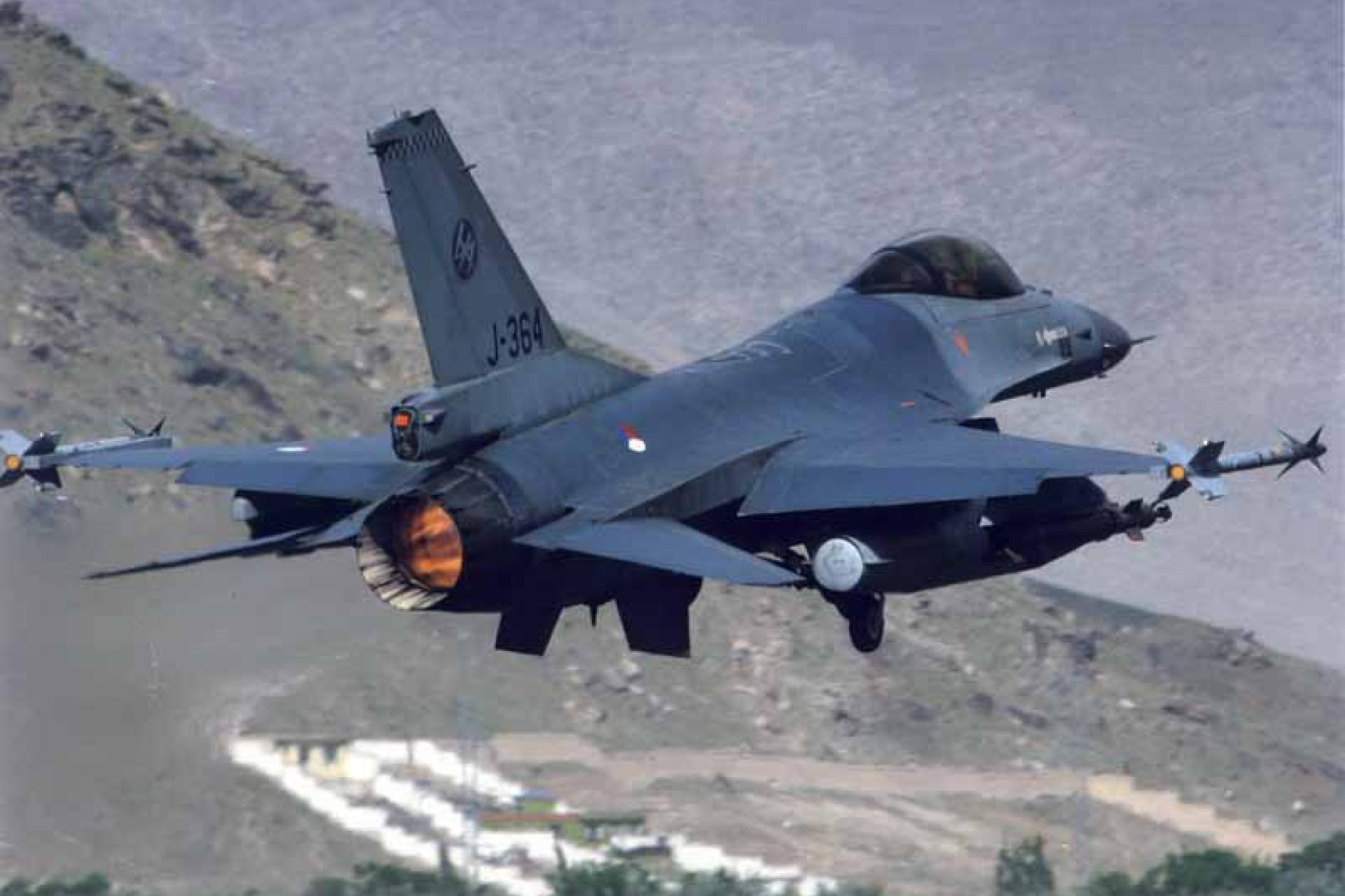 F16 jachtvliegtuig vliegt door bergen