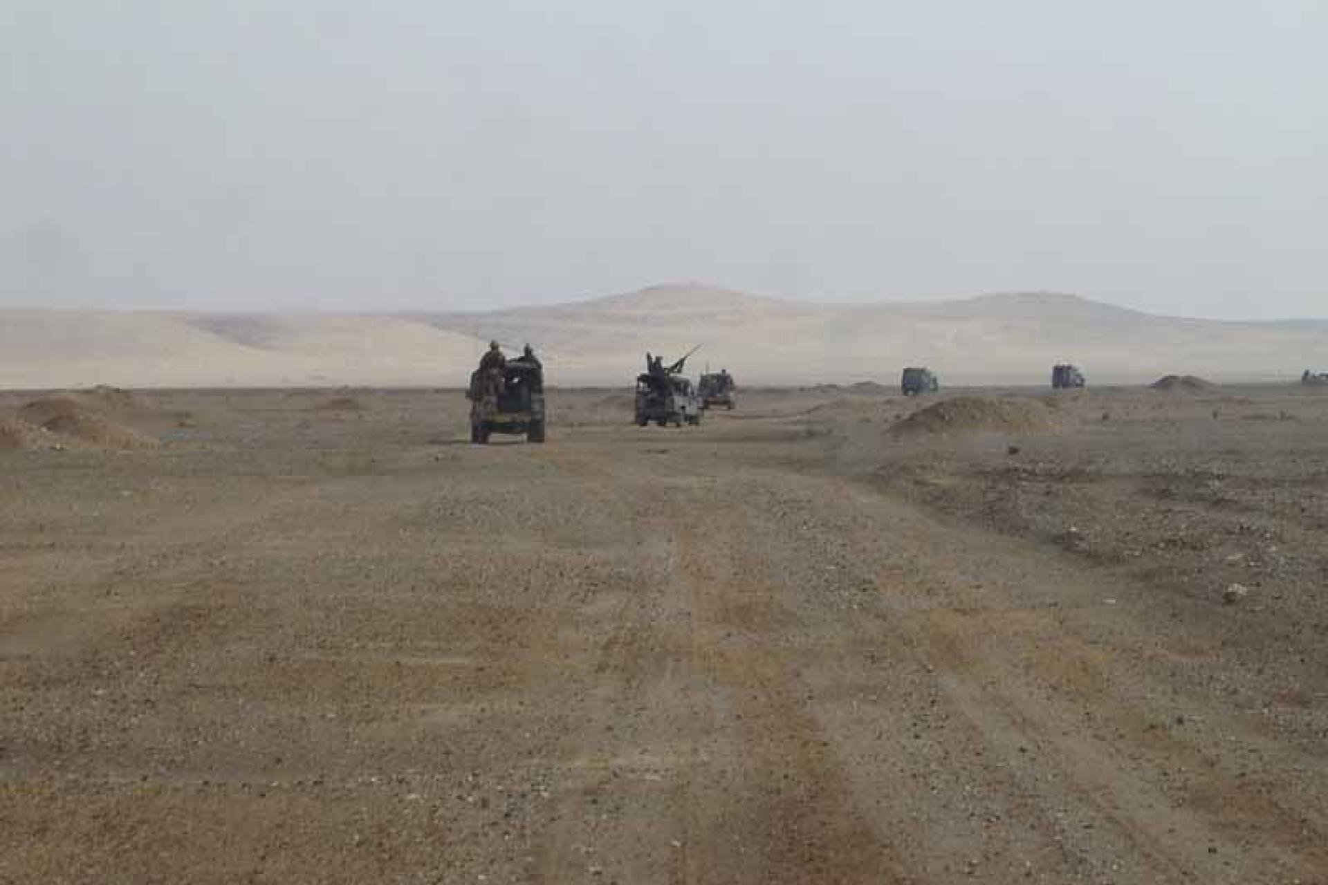Vergroot afbeelding Militaire voertuigen op patrouille in de woestijn