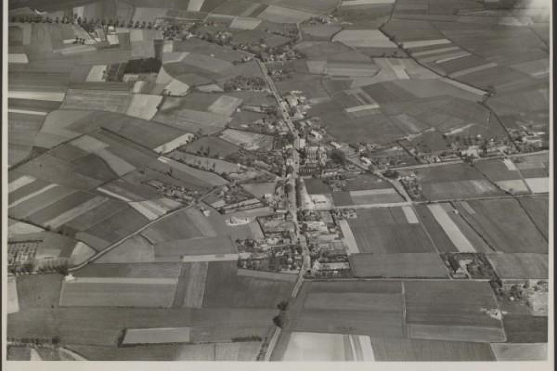 Luchtfoto met daarop huizen en weilanden