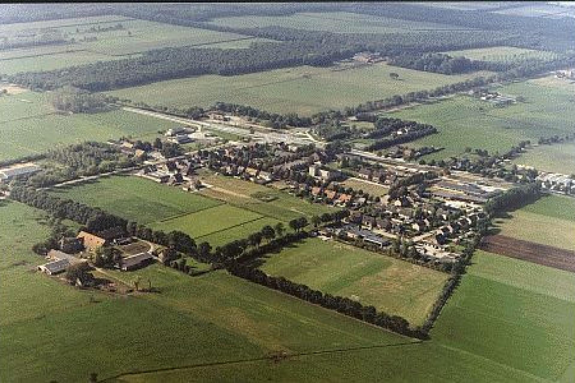 Luchtfoto van Elsendorp met daarop woningen, boerderijen en weilanden